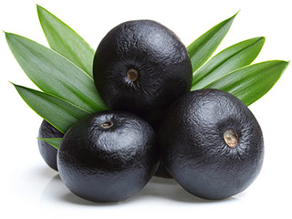 acai berries stacked ontop of each other next to leaves