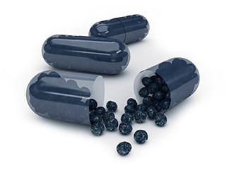 small acai berries coming out of an acai berry capsule