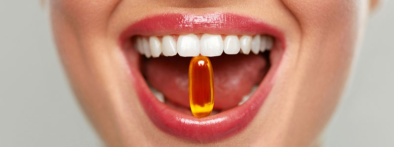 woman biting a softgel capsule with her teeth to represent weightworld supplements