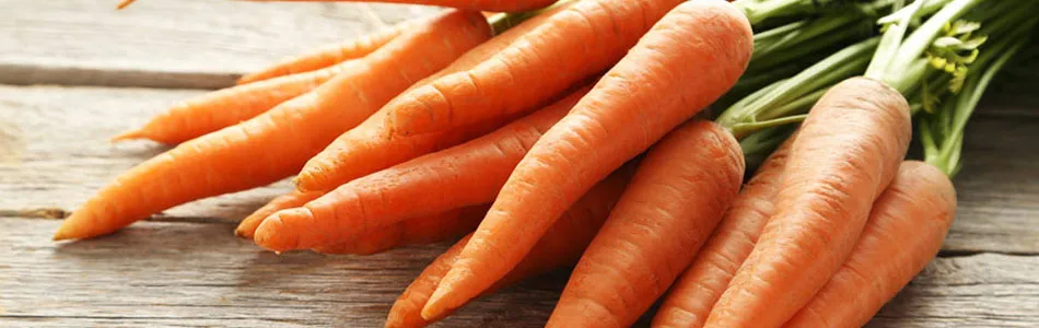 Bunch of carrots on a wooden table with a load of vitamin c