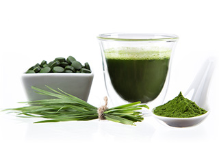 Pot of chlorella tablets, spoonful of powder leaves and drink
