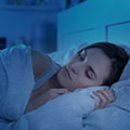 image of a woman sleeping on a bed to show rest to aid recovery