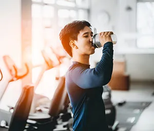 Man Drinking A Creatine Shake At The Gym