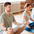 Man and Woman sitting on two yoga mats meditating together
