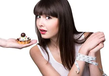 hand with cupcake and women with hands tied by measuring table turning it down