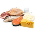 Selection of raw meat for example beef fish chicken and a glass of milk and cheese Selection of raw meat for example beef fish chicken and a glass of milk and cheese