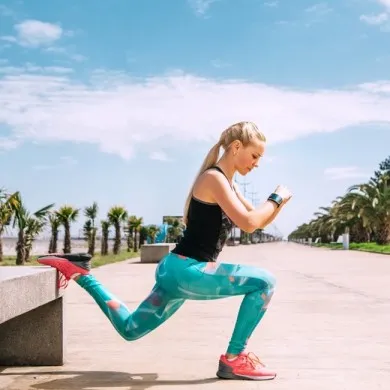 woman dressed in running clothes stretching to show her getting ready for summer