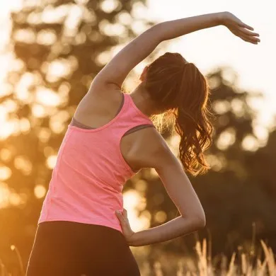 woman in gym clothes doing stretches to indicate she is stretching after a workout