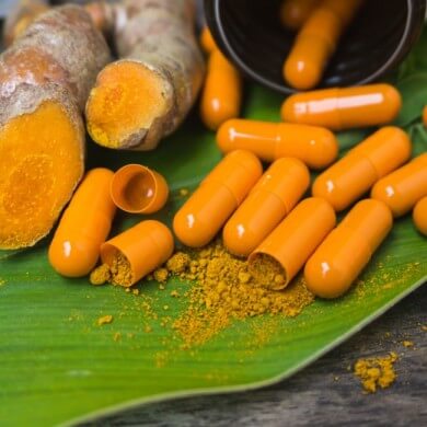 image of turmeric capsules with turmeric powder and ginger