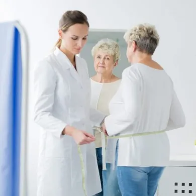 image of a doctor measuring a womans waist to show menopause and weight loss