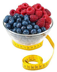 Bowl of raspberries and blueberries with a tape measure around it Bowl of raspberries and blueberries with a tape measure around it