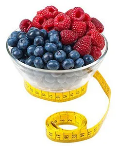 Bowl of raspberries and blueberries with a tape measure around it