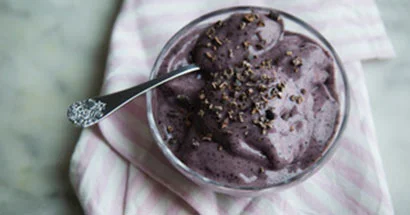 Bowl of healthy nana ice cream with blueberries, banana and cocoa sprinkles. 