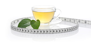 cup of green tea with a leave next to it surrounded by a tape measure