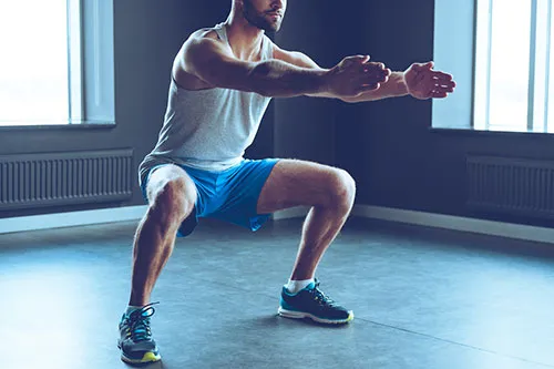 man doing a squat position to show exercise number two