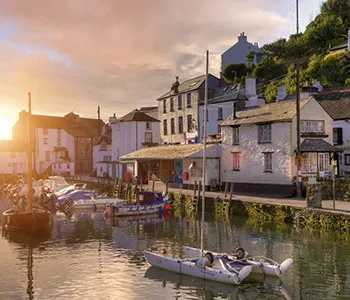 picture of boats on a canal with houses next to the water