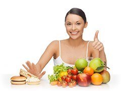 woman saying no to burgers and unhealthy foods and putting thumbs up to fruit and vegetables woman saying no to burgers and unhealthy foods and putting thumbs up to fruit and vegetables