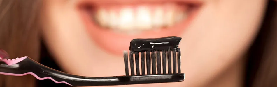 woman with toothbrush with activated charcoal toothpaste