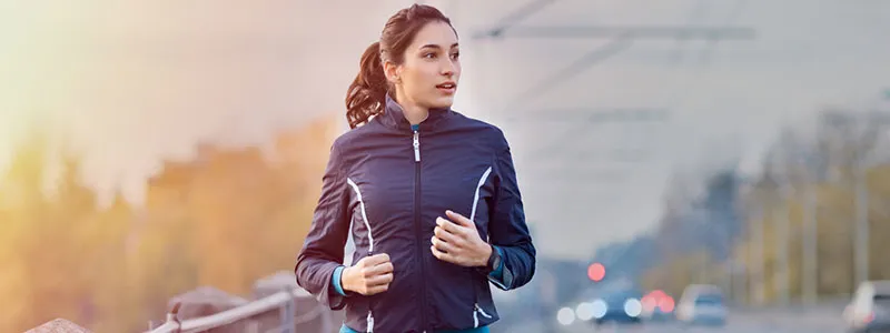 image of woman running on the side of the road to show get moving paragraph