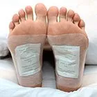 photograph of feet wearing two detox foodpads on foot