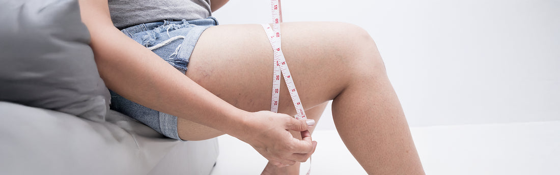 A woman measuring her thighs and showing how to get slim legs without going to the gym.